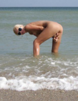 Сексуальная блондинка без трусиков загорает на пляже